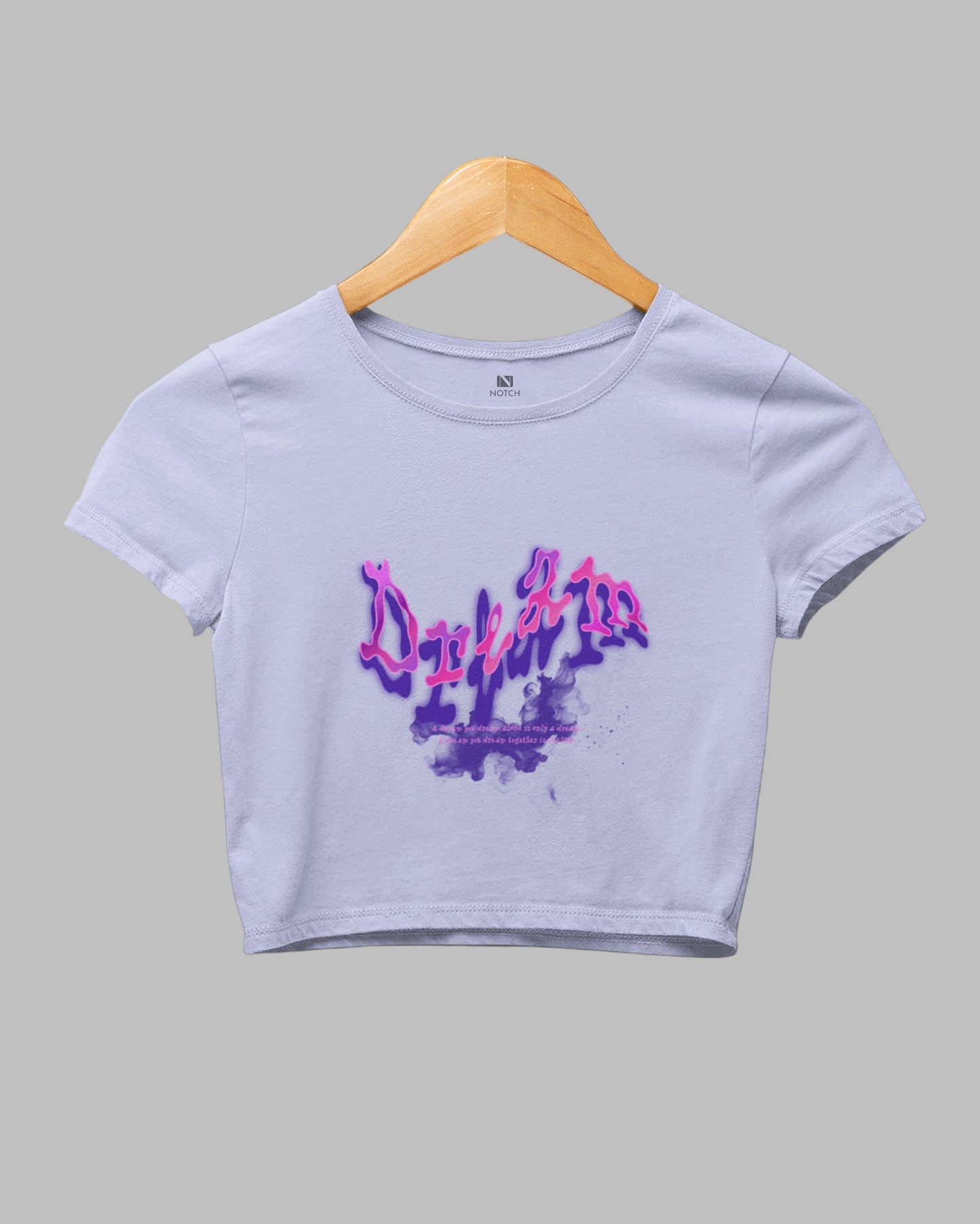 White crop top with purple graphic design on a gray background