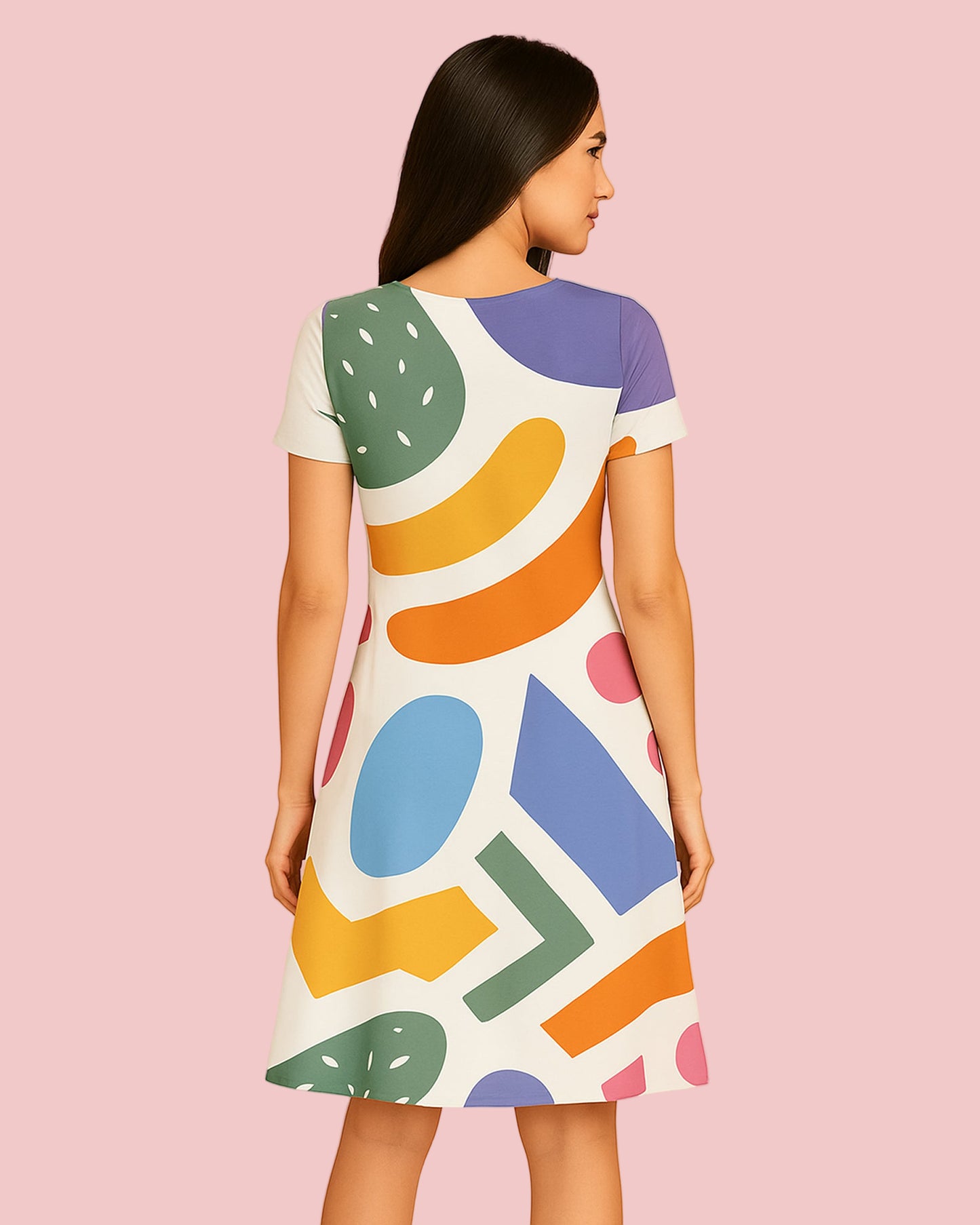 Woman wearing a colorful geometric pattern dress on a pink background