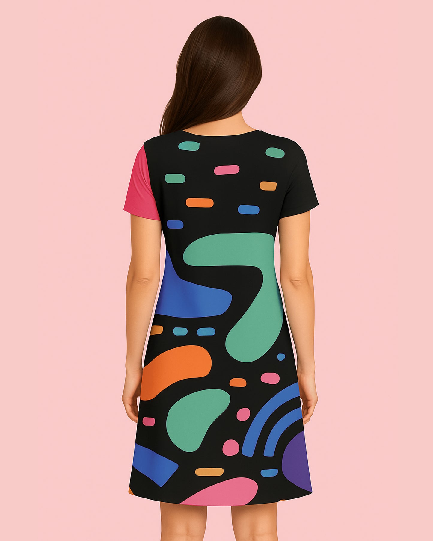 Woman wearing a black dress with colorful abstract patterns on a pink background