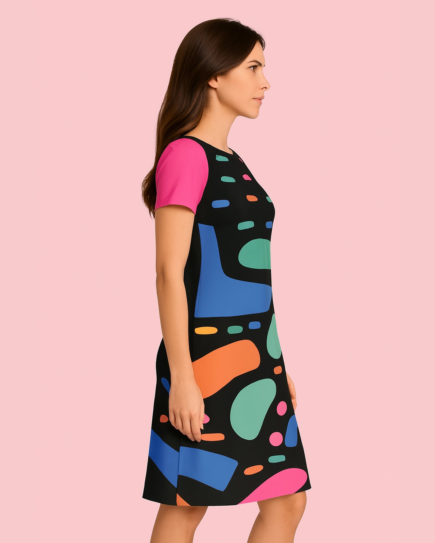 Woman wearing a colorful dress with abstract patterns on a pink background