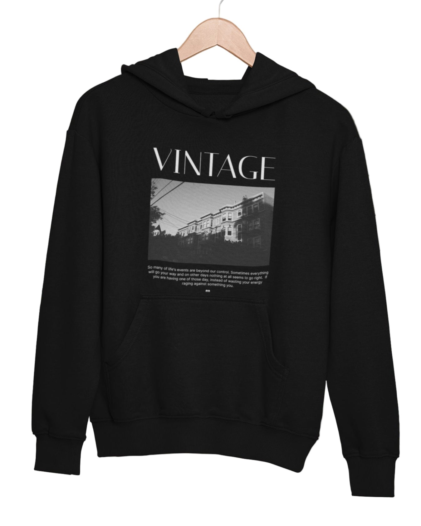 Black hoodie with vintage design on a hanger against a green leafy background