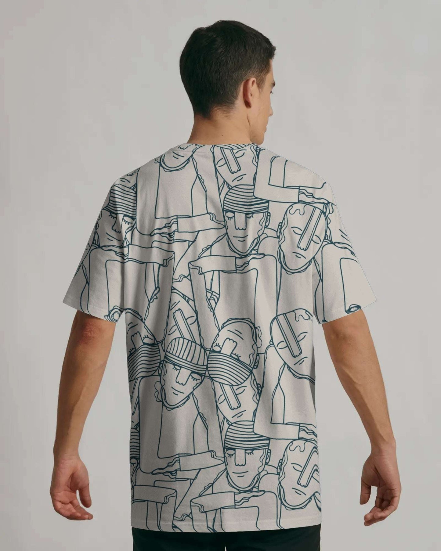 Person wearing a notch white t-shirt with black abstract patterns on a plain background