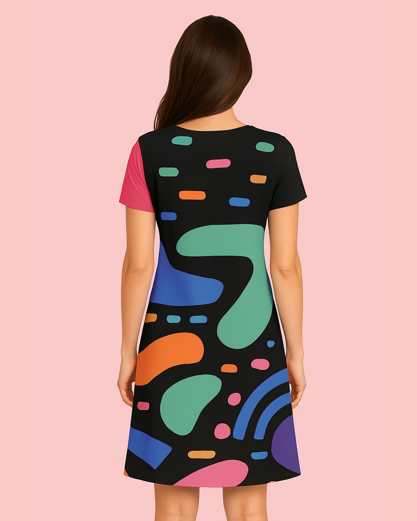 Woman wearing a black dress with colorful abstract patterns on a pink background